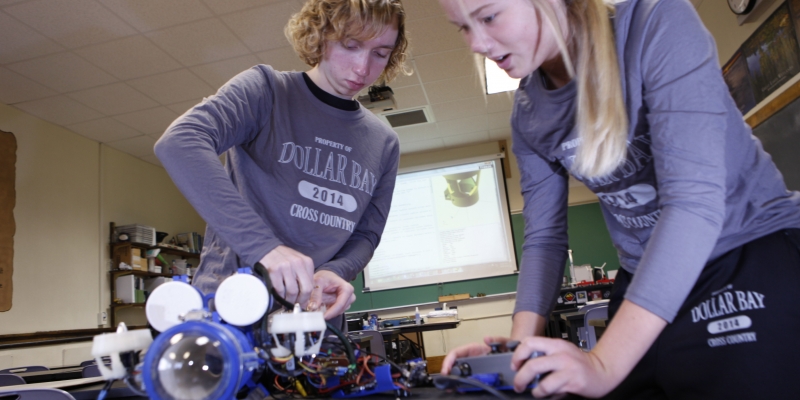 two high school students work on a marine robot